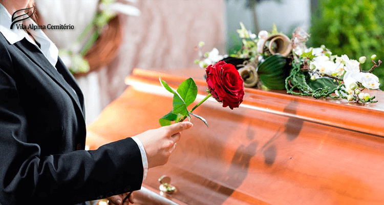 mulher segurando uma rosa perto de um caixão no funeral