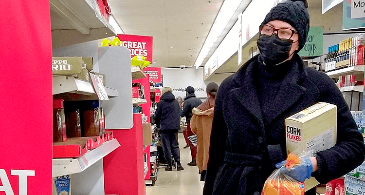 Mulher de máscara fazendo compras no mercado - coronavírus